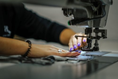 closeup-shot-female-hands-using-sewing-machine